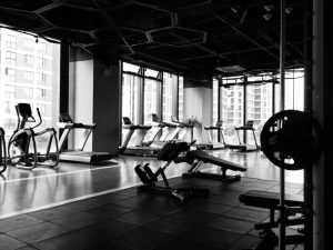 Man doet cardio en krachttraining voor een gezond lichaam op fitnessapparatuur