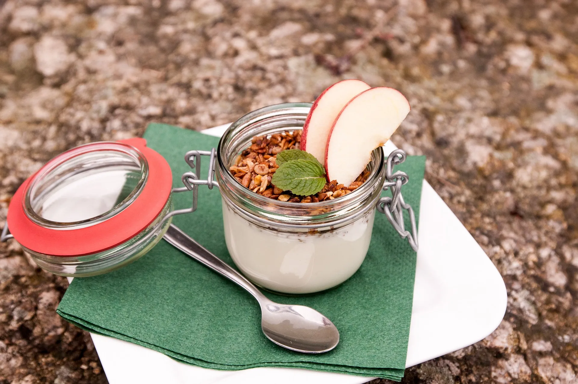 Een frisse vegan lunch met yoghurt, knapperige granola en appel voor een gezonde middag.