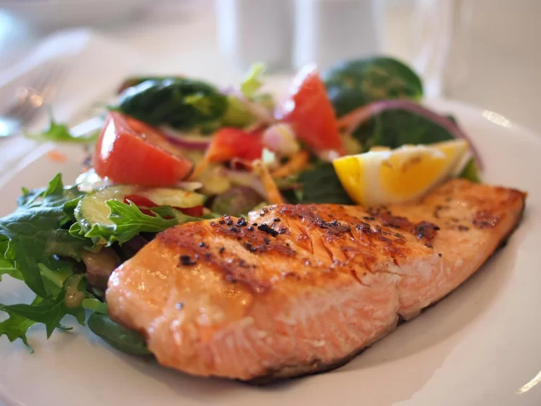 Gegrilde zalm met frisse salade en citroen, ideaal als gezonde werklunch.