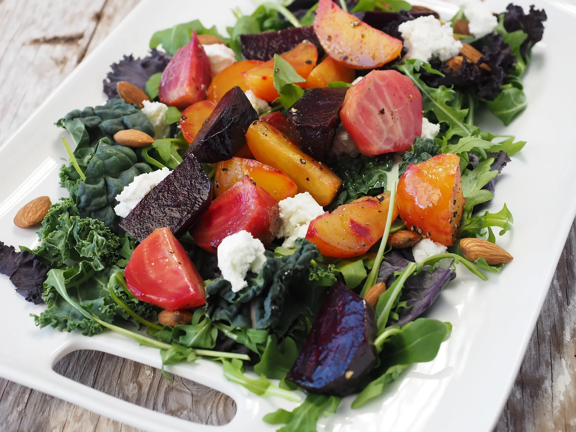 Gezonde lunchsalade met biet, geitenkaas, noten en groene bladgroenten.