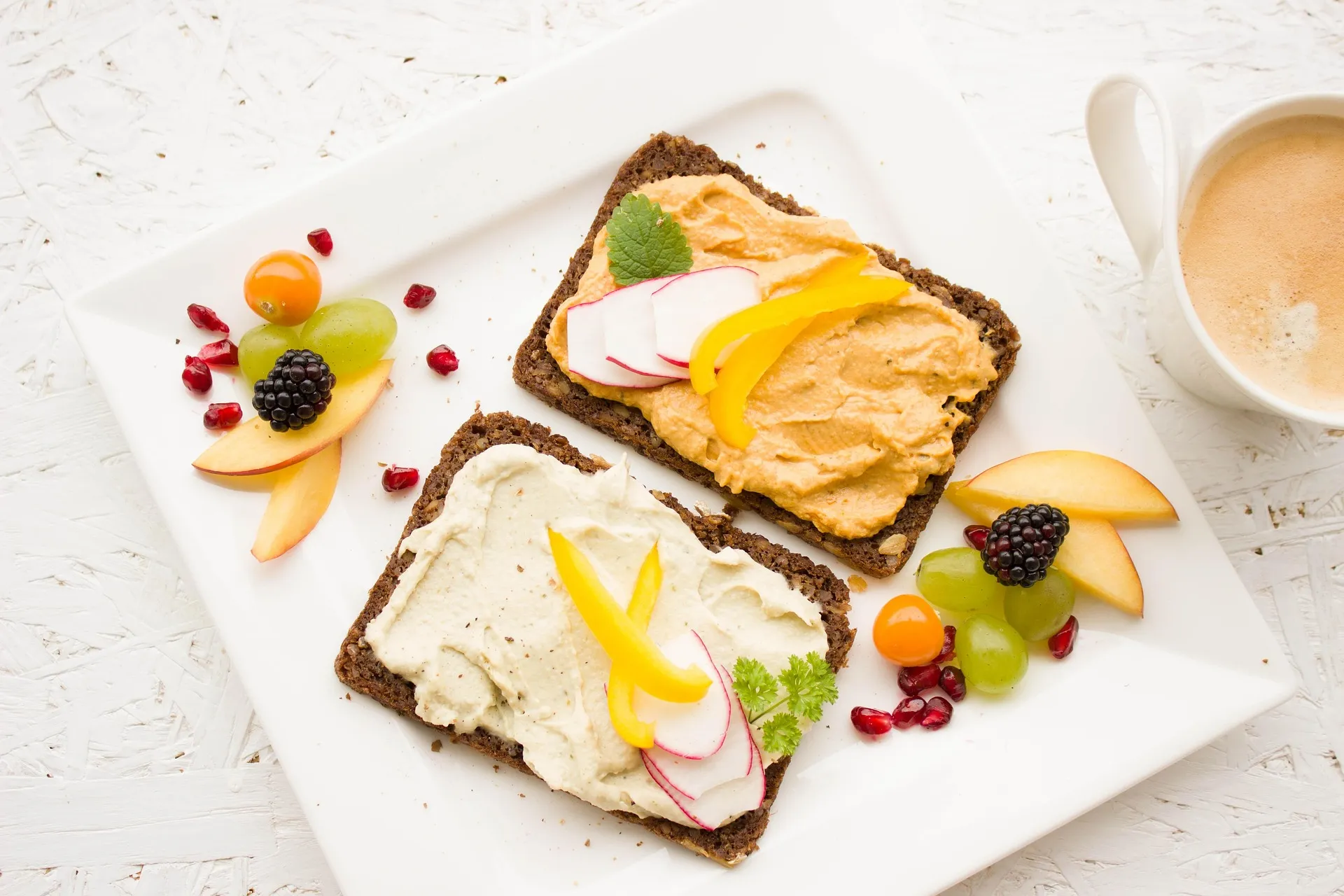 Volkoren toast met hummus, paprika en radijs voor een frisse en voedzame lunch.