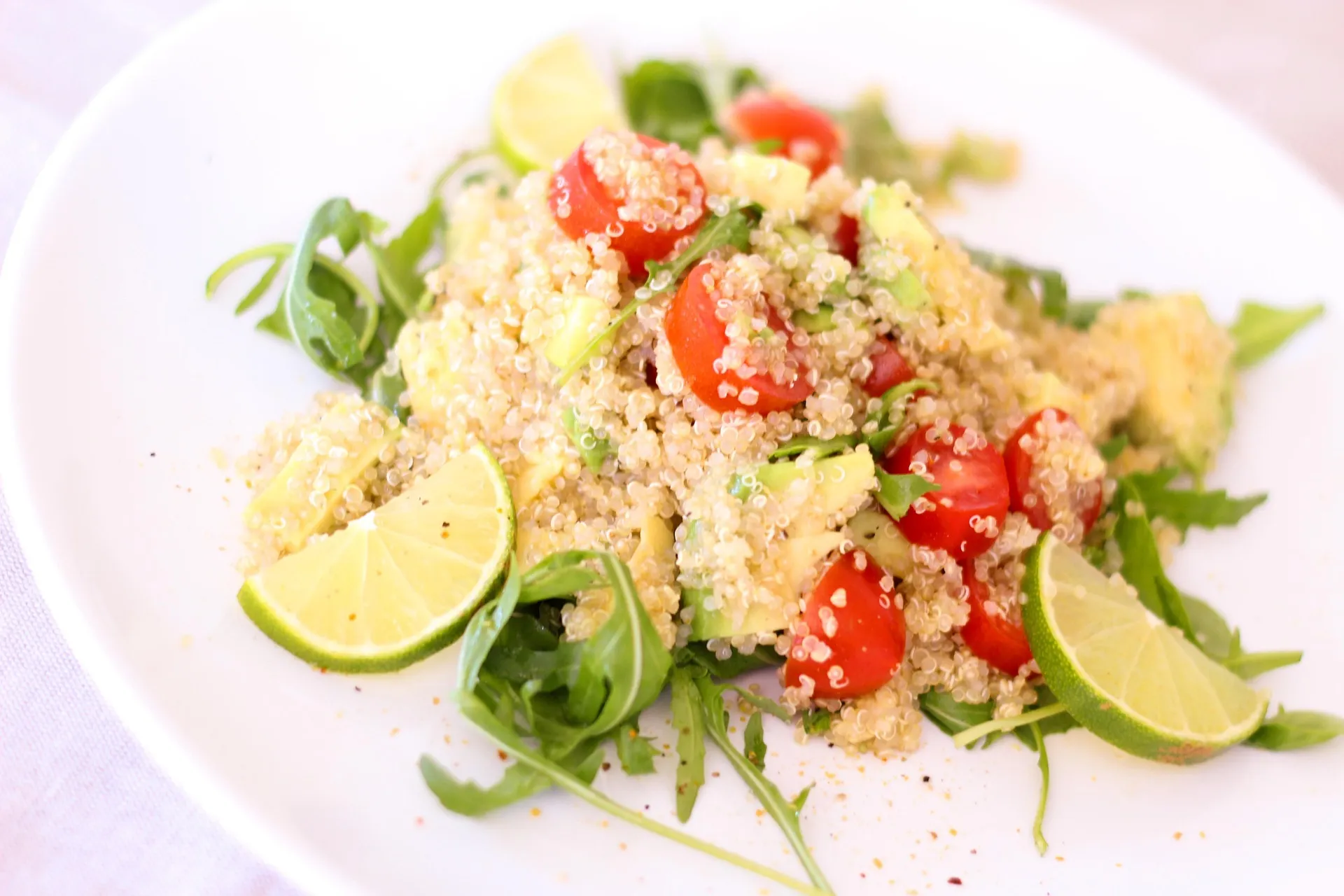 Frisse quinoasalade met tomaat, rucola en limoen voor een lichte lunch.