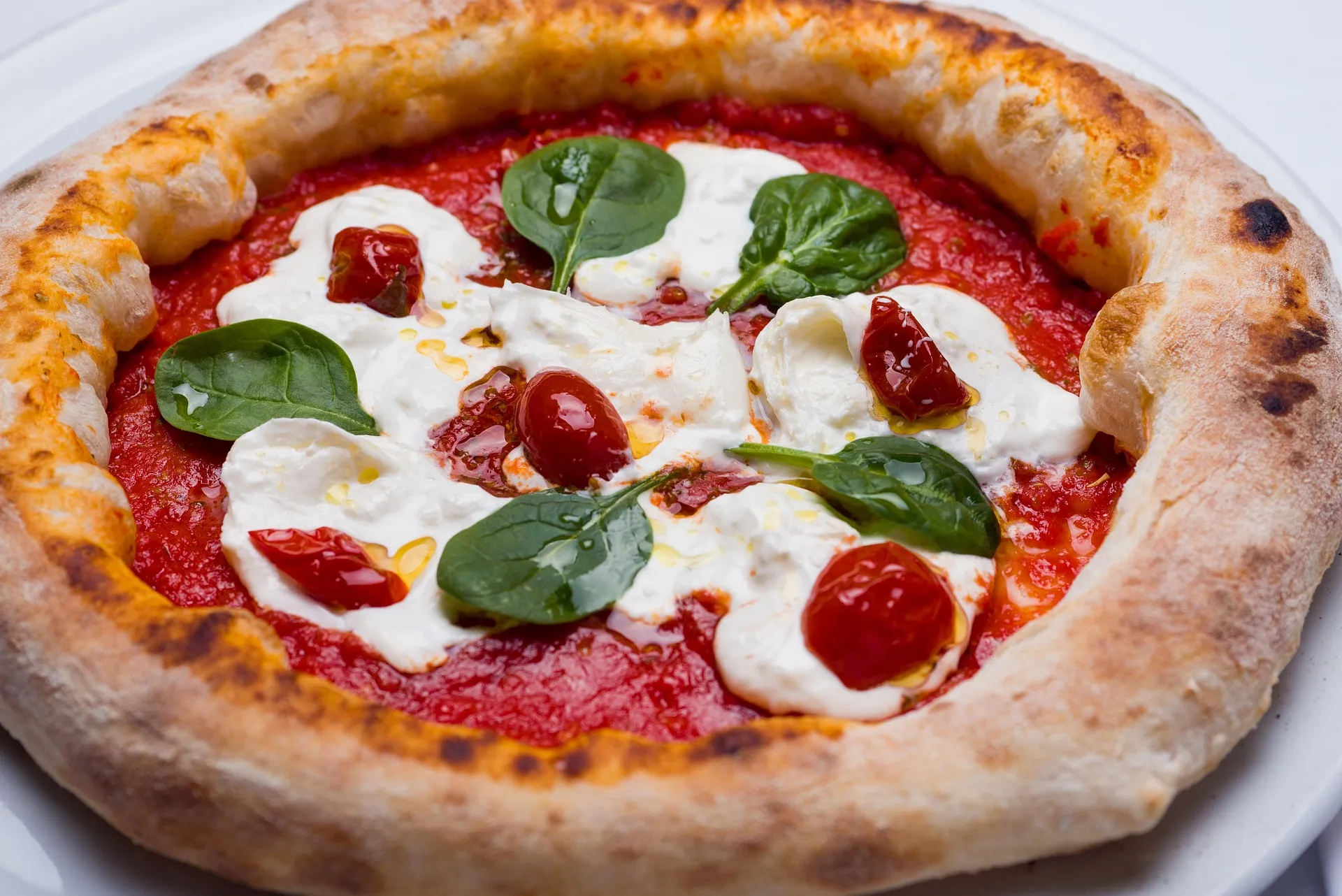 Een vullende pizza met romige kaas, tomaat en verse basilicum voor een smakelijke middag.