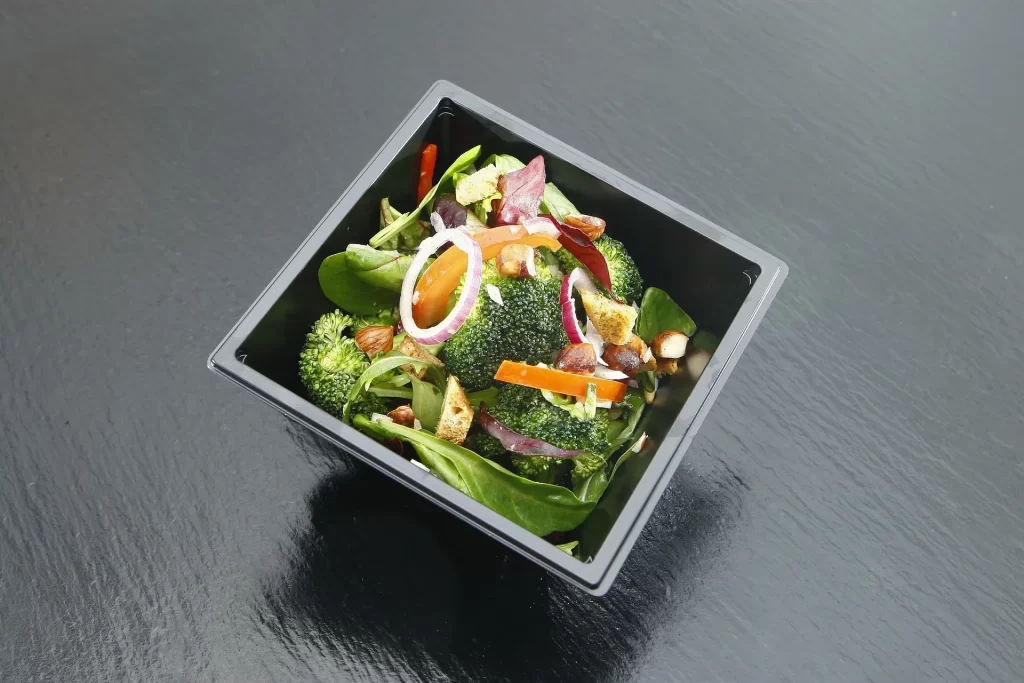 Frisse meeneemsalade met broccoli, spinazie en groenten voor een gezonde lunchpauze.