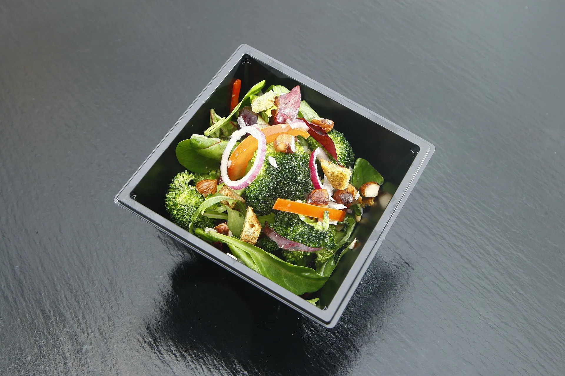 Frisse meeneemsalade met broccoli, spinazie en groenten voor een gezonde lunchpauze.