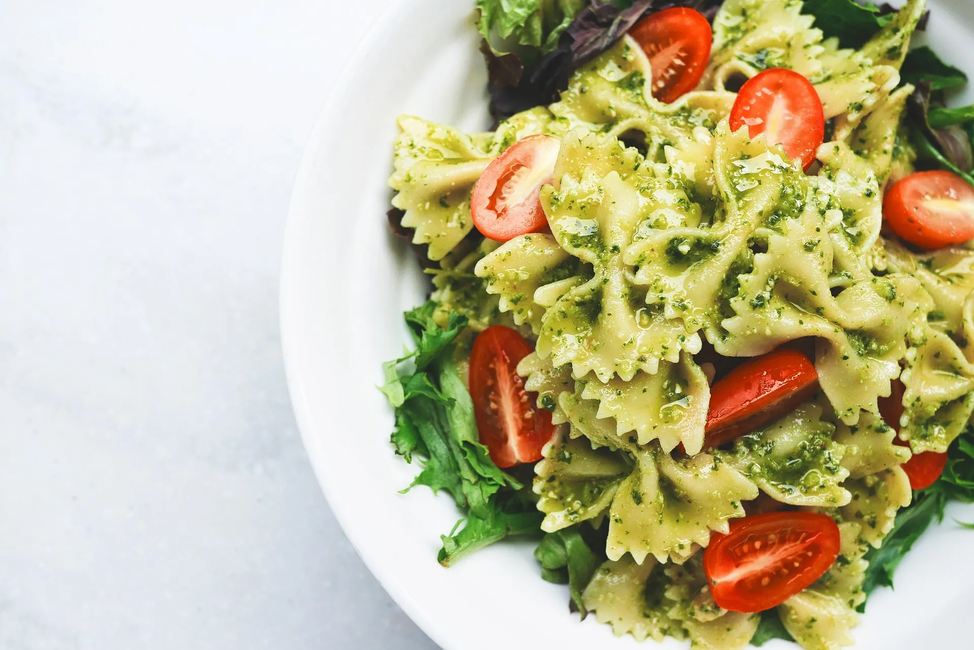 Frisse pastasalade met pesto, tomaat en bladgroenten voor een makkelijke lunch op kantoor.