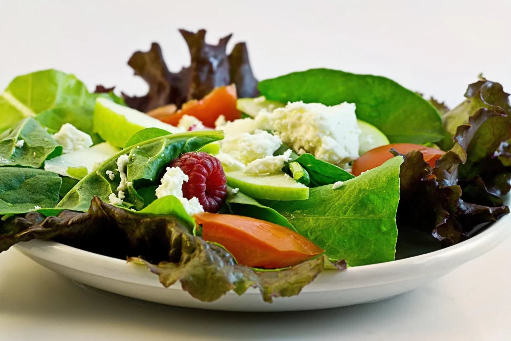 Frisse salade met veel groenten, feta en fruit voor een lichte gezonde lunch.